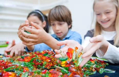 Elementary school children play with colorful crystals — museum education program for elementary schools at Swarovski Kristallwelten.