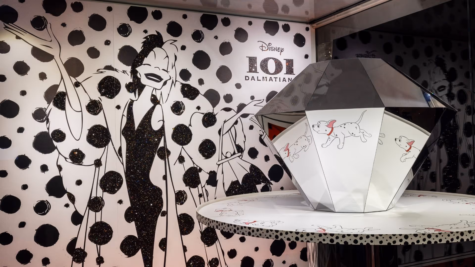 Disney 101 Dalmatiner Kunstbühne im Swarovski Kristallwelten Store Wattens – funkelnde Illustration von Cruella de Vil vor schwarz-weißem Punktedesign und Praxinoskop mit Dalmatiner-Motiven.