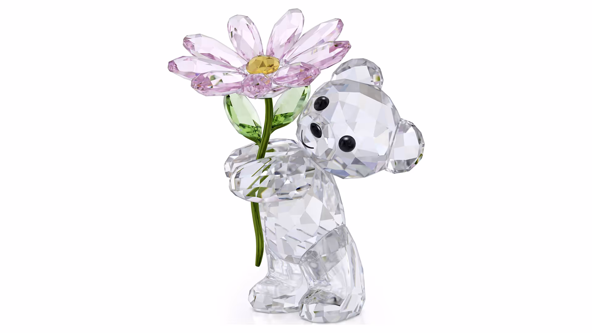 Crystal figure of a small, faceted bear from Swarovski holding a large, pink crystal flower with a yellow center and green leaves. The figure looks playful and affectionate and is made of clear, sparkling crystal stones.
