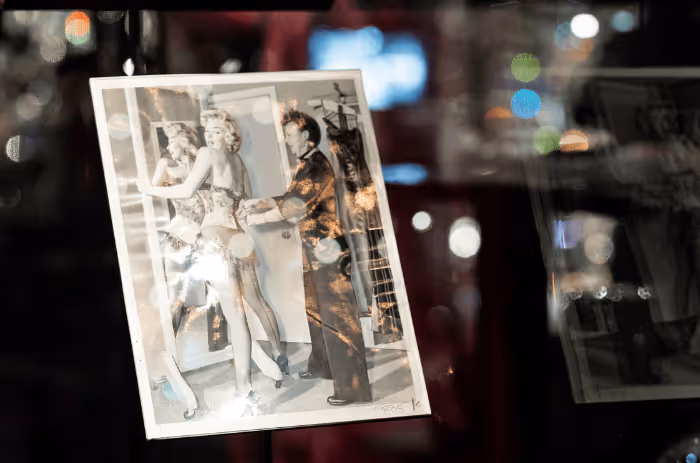 Black and white photograph of Marilyn Monroe trying on a dress, exhibited in the Chamber of Wonder “The Art of Performance” at Swarovski Kristallwelten.