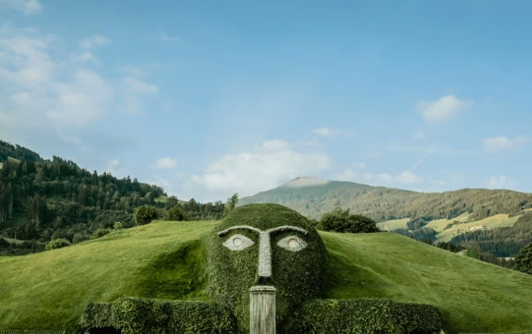 Der markante Riese mit leuchtenden Augen und Wasserfall ist das Herzstück der Swarovski Kristallwelten Wattens, umgeben von der Tiroler Bergkulisse.
