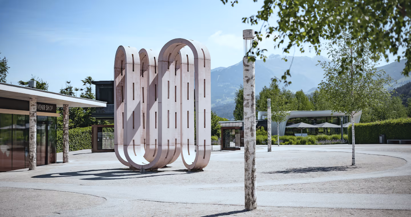 Kunstwerk 'Conveyor Belt': Große rosafarbene Skulptur im Freien, bestehend aus geschwungenen, organischen Formen.