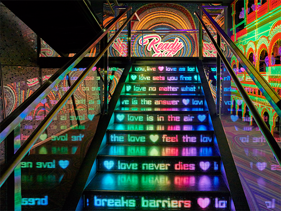 Installation 'Ready to Love': Eine Treppe mit Neonschriftzügen, "Love never dies".