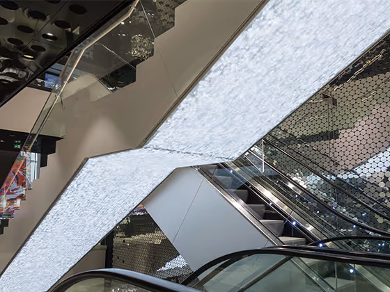 Installation 'Caustic Rays': Funkelnde Kristallflächen entlang einer Rolltreppe erzeugen faszinierende Lichtreflexe.