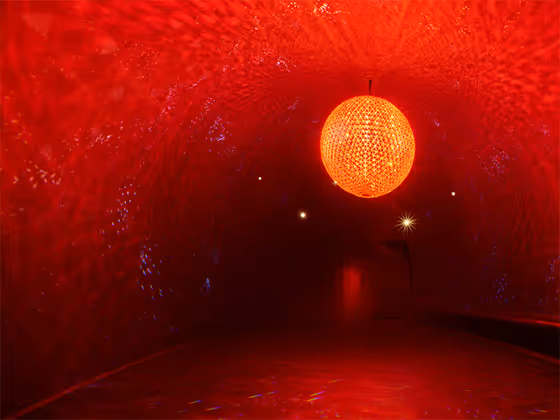 Skulptur 'El Sol': Riesige Kristallkugel in warmem Licht, die an eine Sonne erinnert.