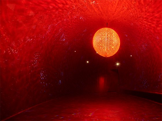 Skulptur 'El Sol': Riesige Kristallkugel in warmem Licht, die an eine Sonne erinnert.