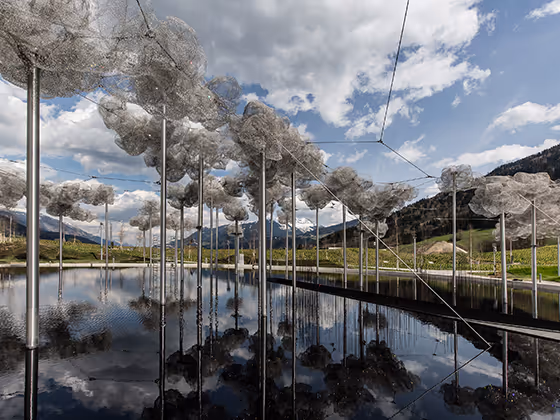 Installation 'Kristallwolke': Tausende funkelnde Kristalle hängen über einem dunklen Wasserbecken und spiegeln sich.