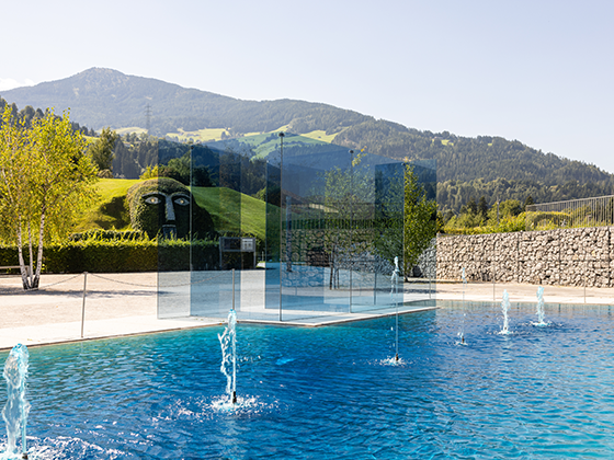 Installation 'Ford Crystal Blue': Ein blaues Glaskonstrukt in einem blauen Wasserteich vor den Swarovski Kristallwelten.