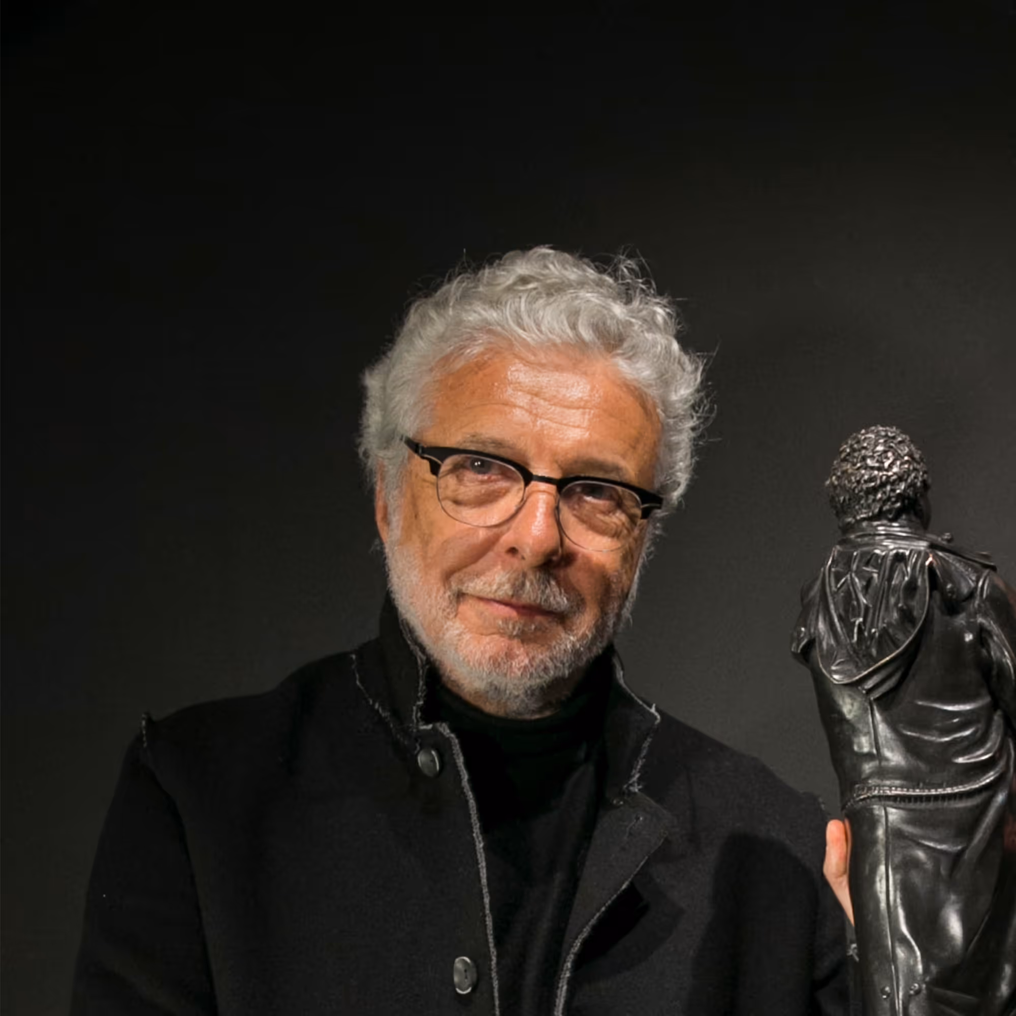 André Heller, österreichischer Künstler und Multitalent, 2018 im eleganten Anzug mit Bart, freundlich lächelnd im Porträt.