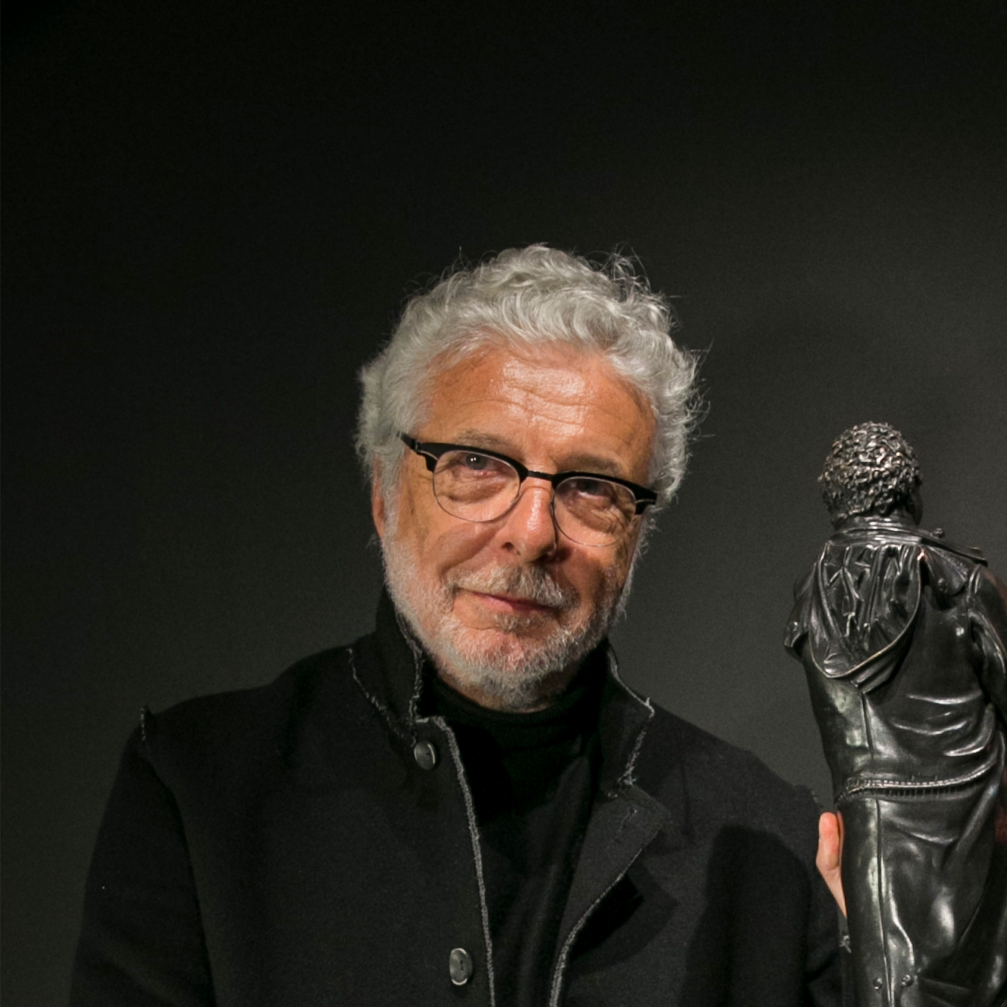André Heller, österreichischer Künstler und Multitalent, 2018 im eleganten Anzug mit Bart, freundlich lächelnd im Porträt.