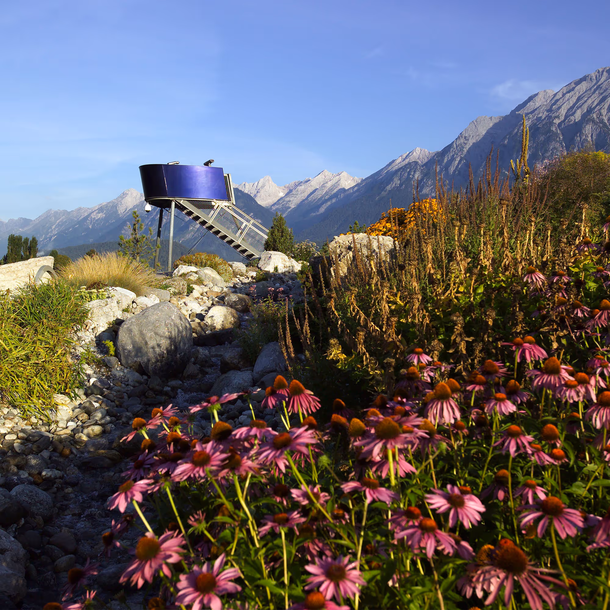 Aussichtsturm im Alpengarten der Swarovski Kristallwelten: Moderner Metallturm mit Blick auf die Tiroler Bergwelt.