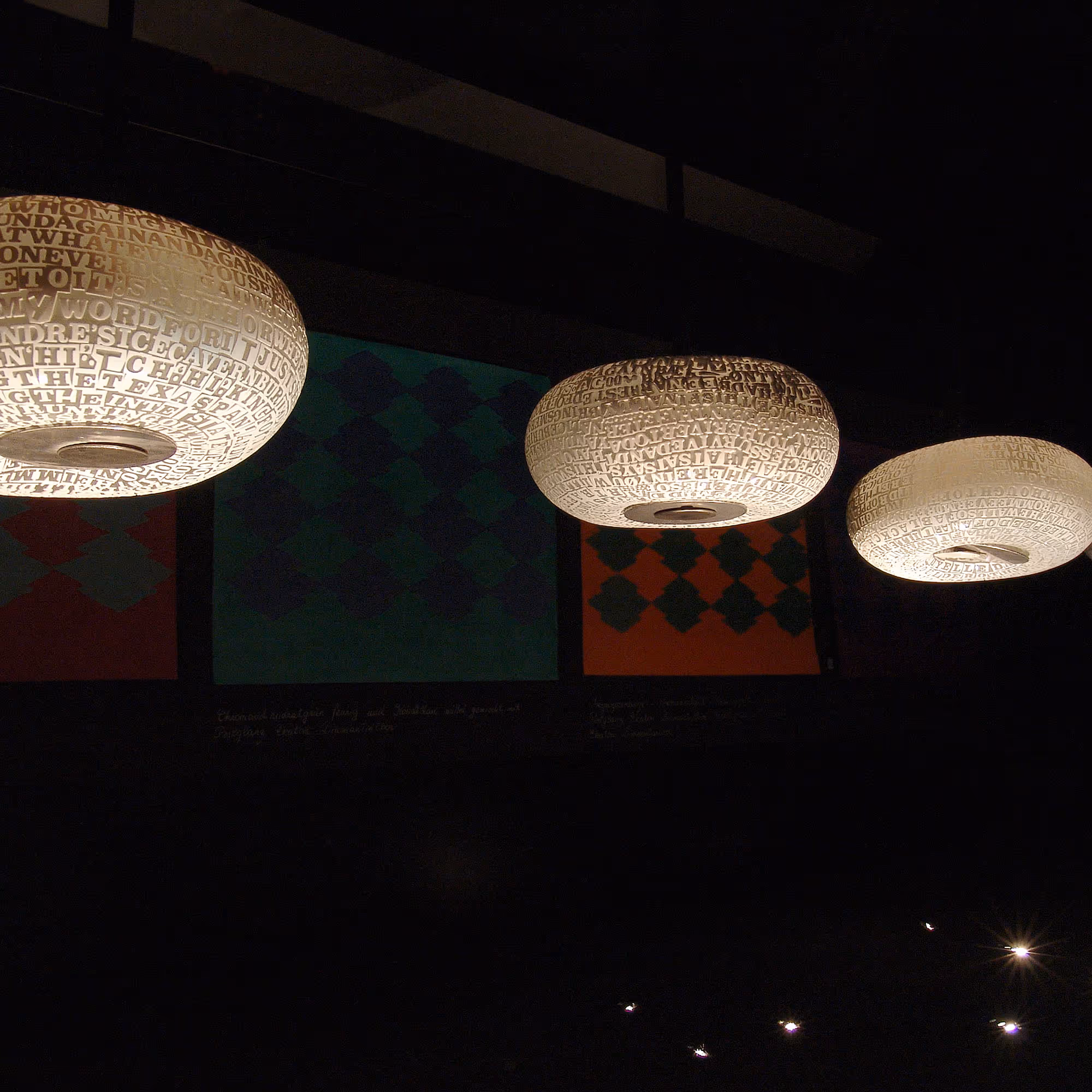 John Brekke, 2004 – Kunstwerk mit leuchtenden Lampenschirmen, die mit Textmustern versehen sind.