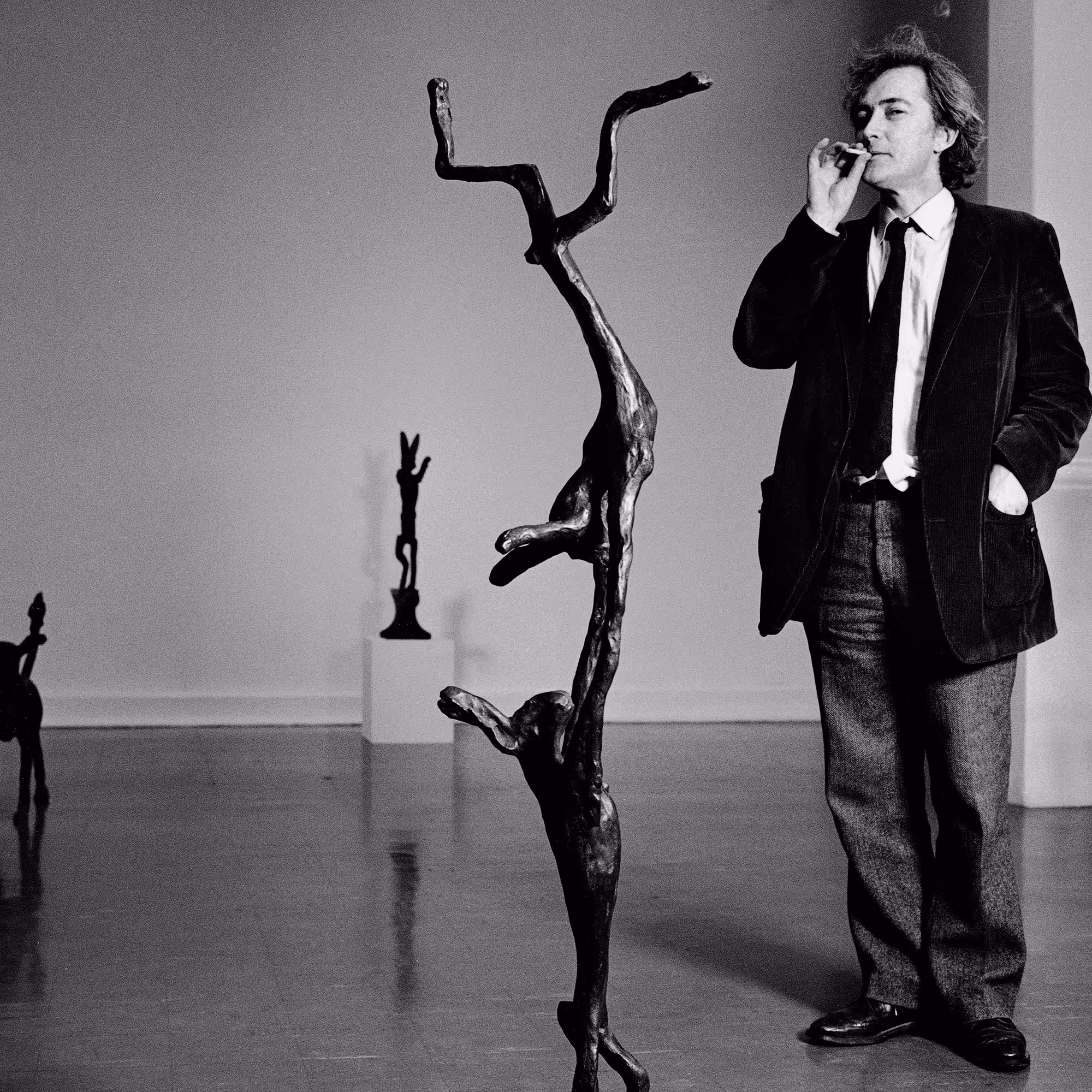 Barry Flanagan, britischer Künstler, im Schwarz-Weiß-Porträt mit Brille, Anzug und nachdenklichem Gesichtsausdruck.