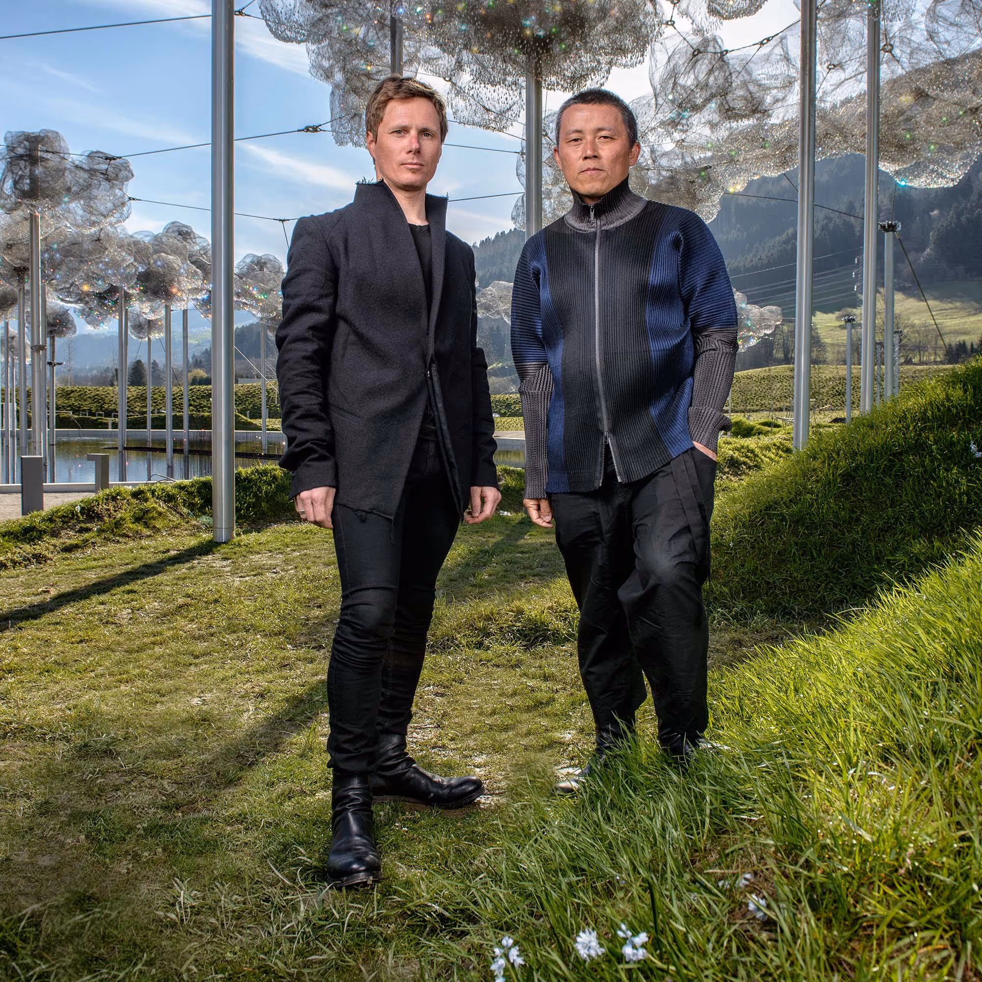 Cao Perrot, französisches Künstlerduo, 2015 gemeinsam im Porträt, schlicht gekleidet vor der Kristallwolke im Park.