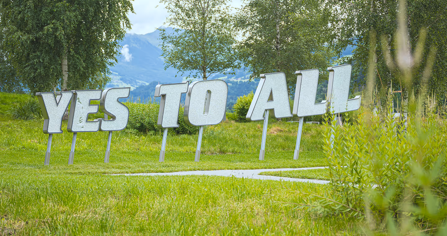Installation 'Yes to All': Überdimensionaler Kristallschriftzug, der eine Botschaft von Offenheit vermittelt.