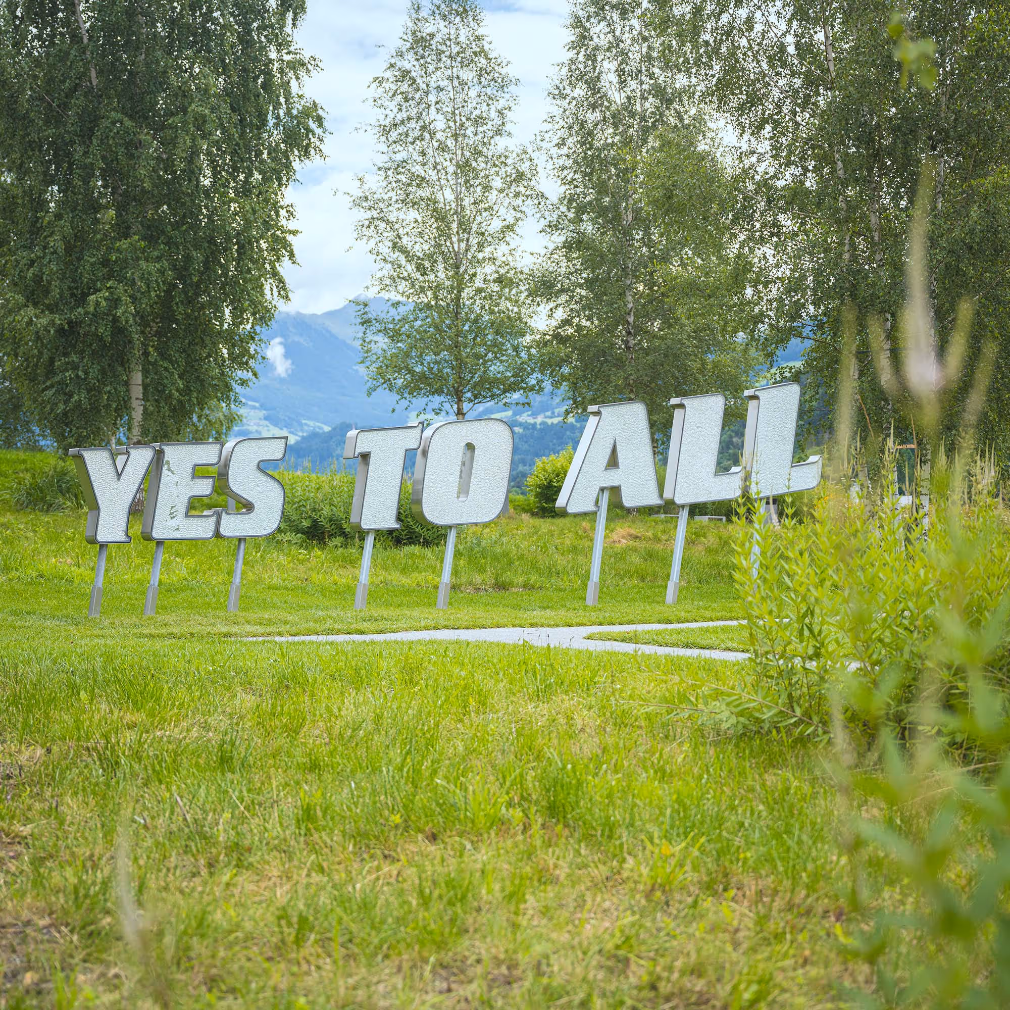 Installation 'Yes to All': Überdimensionaler Kristallschriftzug, der eine Botschaft von Offenheit vermittelt.