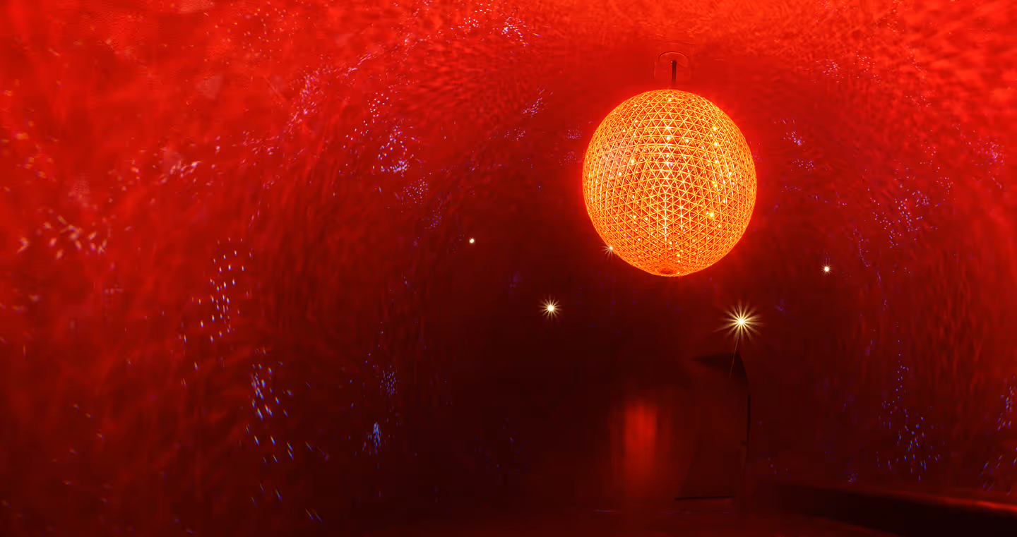 Skulptur 'El Sol': Riesige Kristallkugel in warmem Licht, die an eine Sonne erinnert.