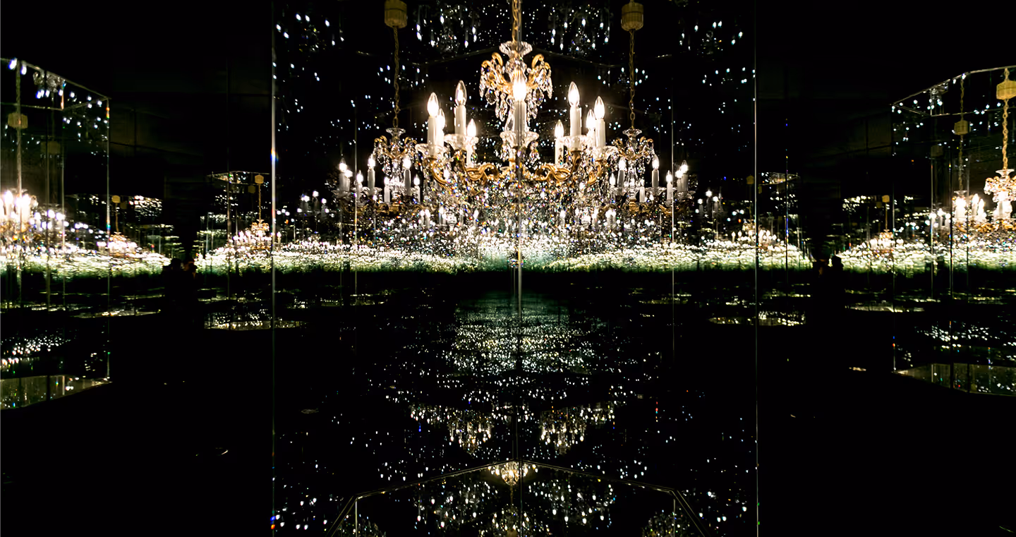 Kunstwerk 'Chandelier of Grief': Ein Kristallluster in einem Spiegelraum, der durch Reflexionen endlos erscheint.