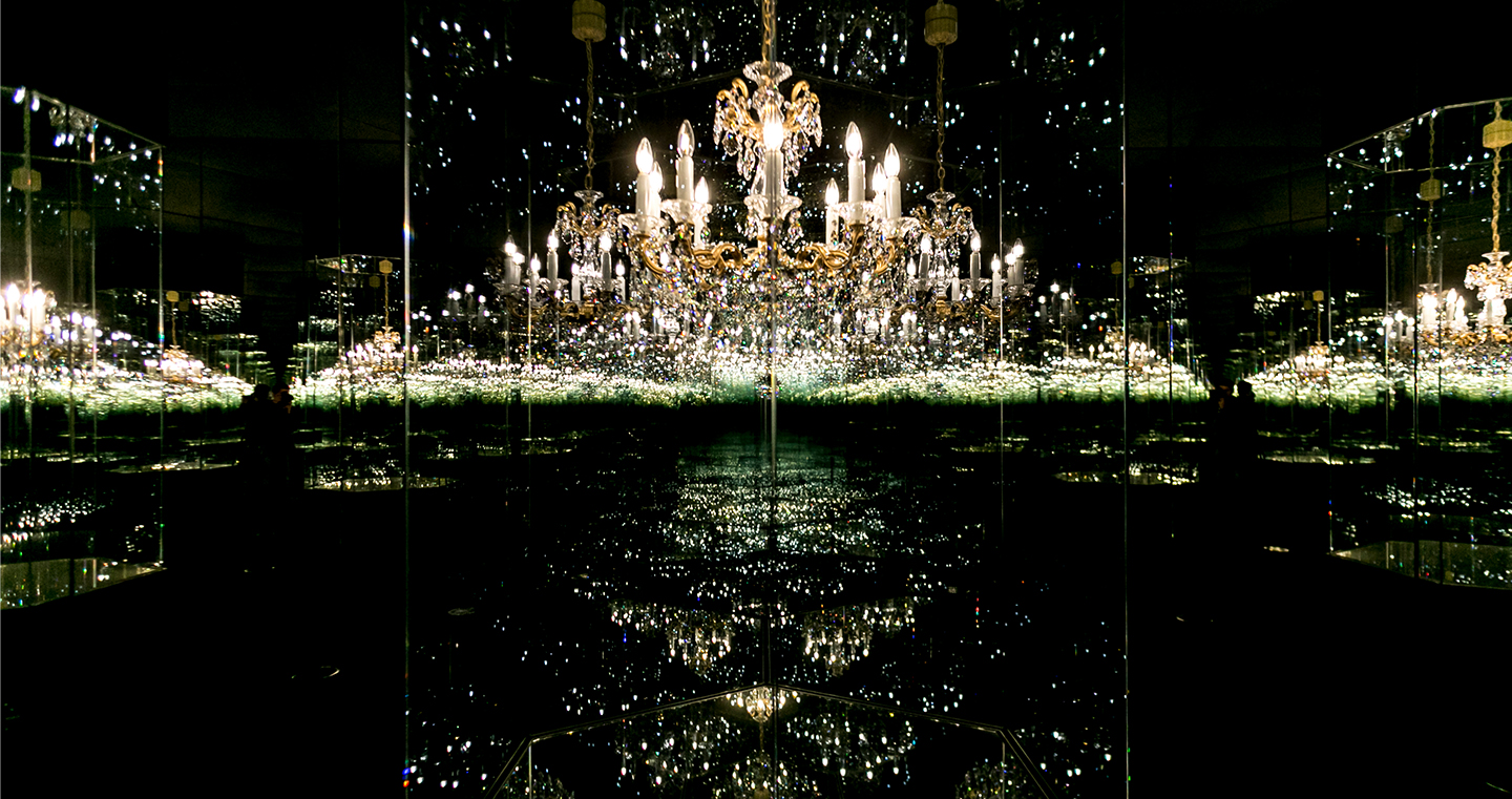 Kunstwerk 'Chandelier of Grief': Ein Kristallluster in einem Spiegelraum, der durch Reflexionen endlos erscheint.