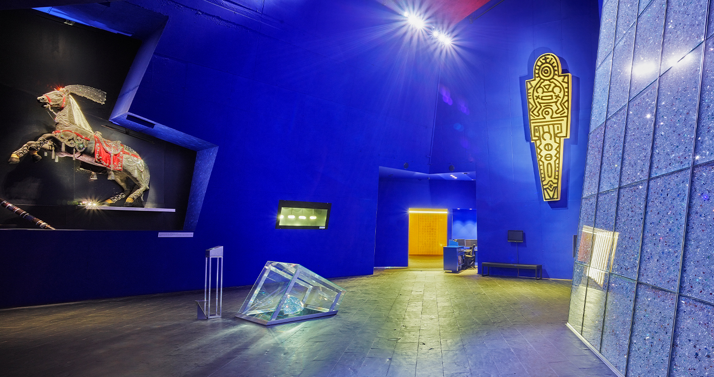 Die Blaue Halle: Ein Raum mit intensiver in einem Blau, mit vielen Kunstwerken an den Wänden. In der Mitte ein großer Kristall.