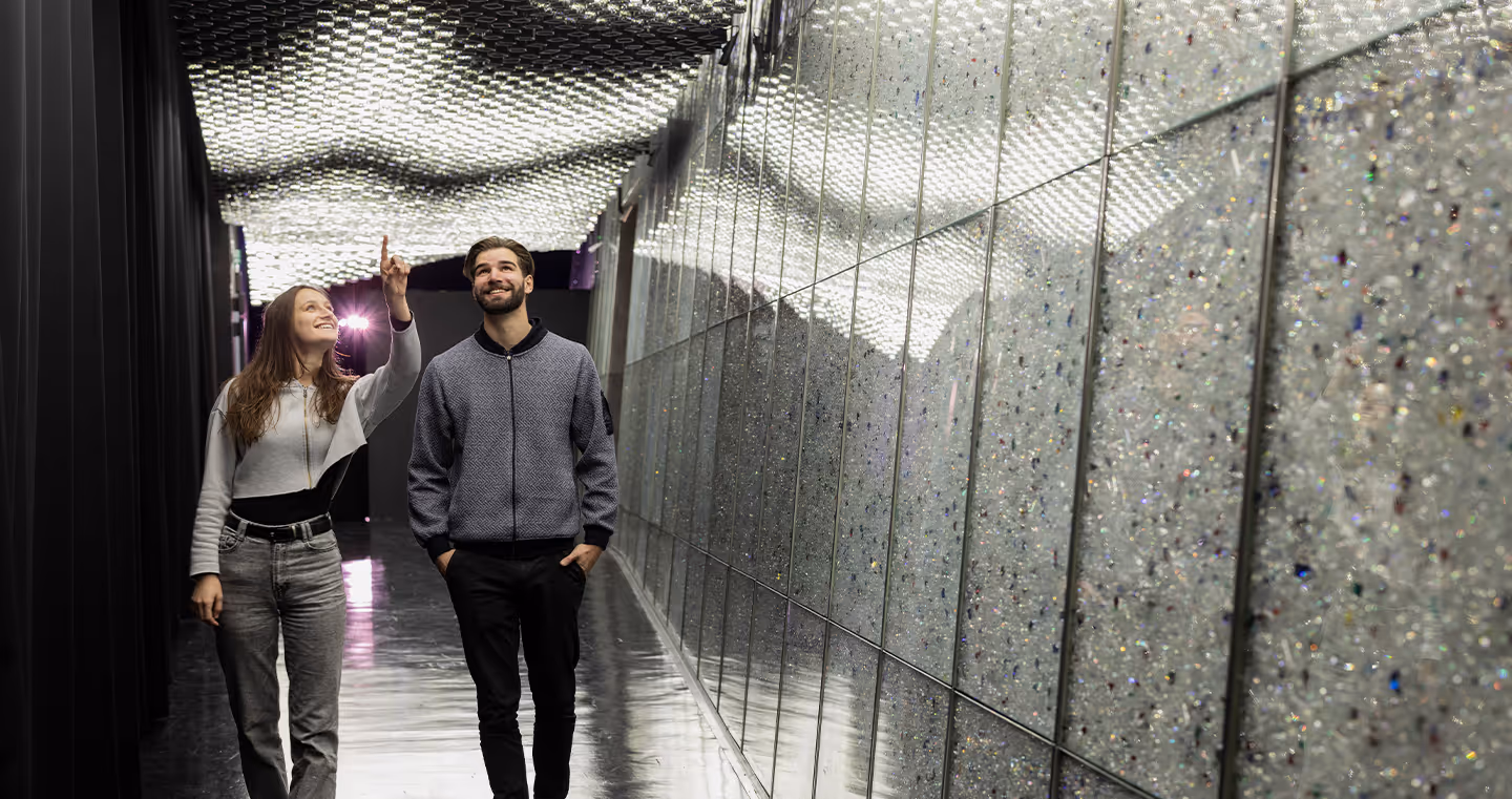 Installation 'Kristallstimmen': Dunkler Raum, in dem Kristalle mit Lichteffekten und Klang kombiniert werden.