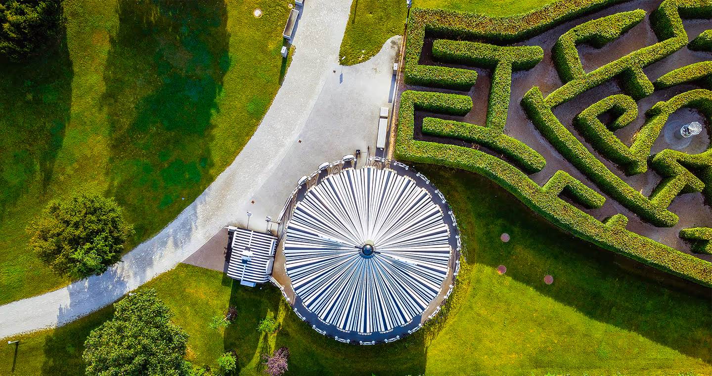 Labyrinth im Park: Geometrisch gestaltete Heckenanlage, die Besucher zum Erkunden einlädt.