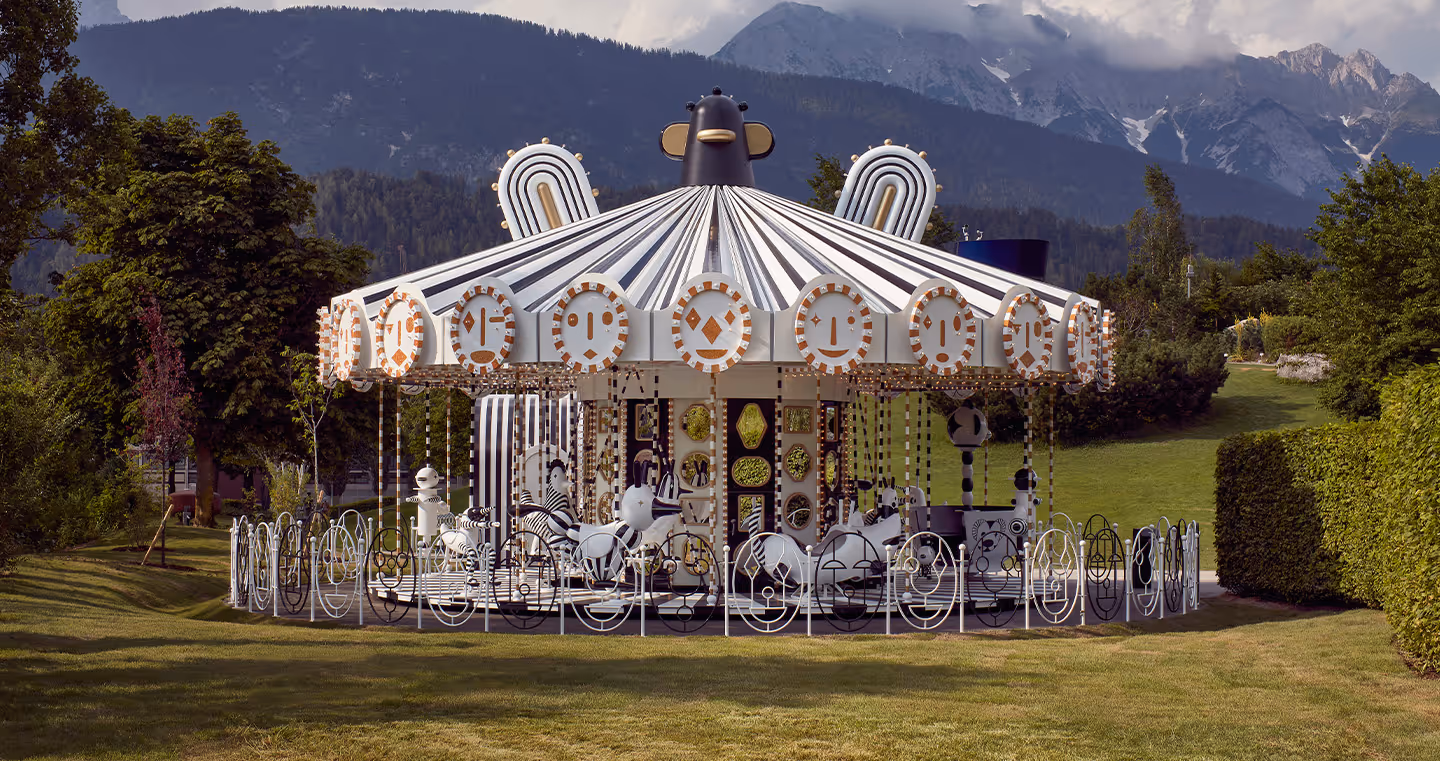 Karussell in Schwarz-Weiß mit fantasievollen Ornamenten und Kristalldetails, aufgestellt im Garten der Swarovski Kristallwelten.