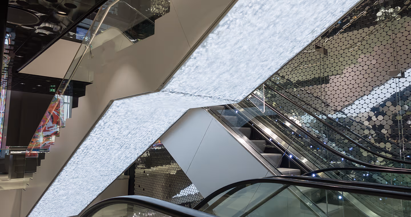 Installation 'Caustic Rays': Funkelnde Kristallflächen entlang einer Rolltreppe erzeugen faszinierende Lichtreflexe.