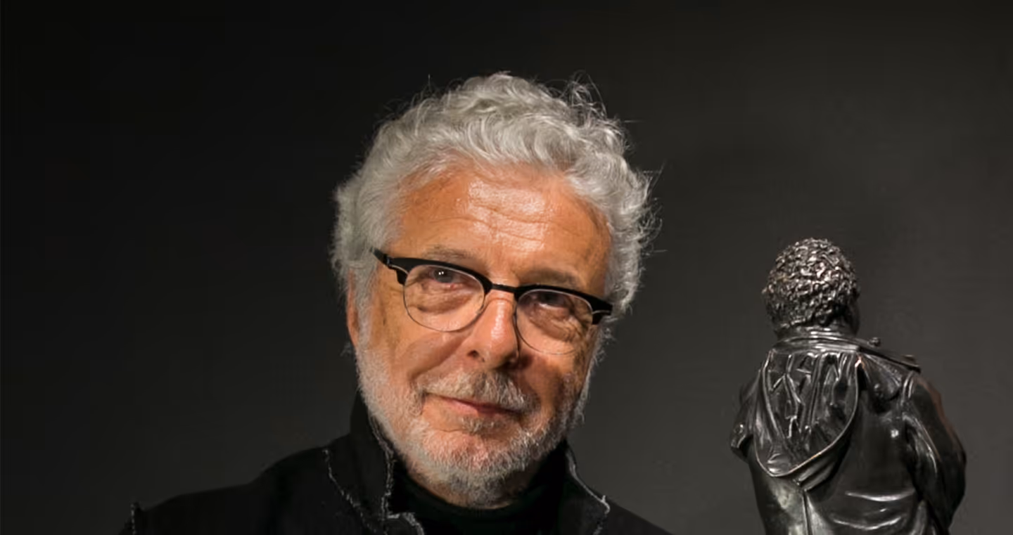 André Heller, österreichischer Künstler und Multitalent, 2018 im eleganten Anzug mit Bart, freundlich lächelnd im Porträt.