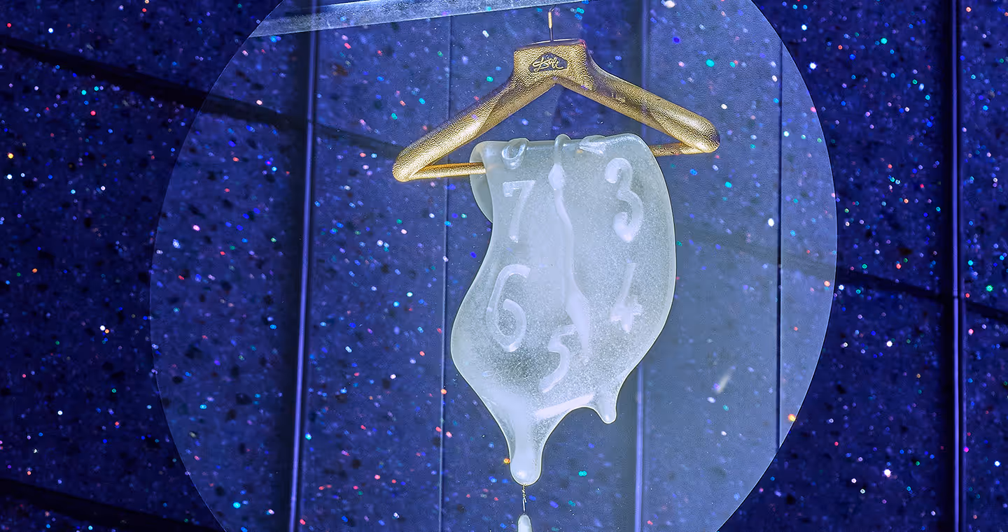 Surreales Werk inspiriert von Salvador Dalí: Eine schmelzende Uhr mit fließender Form hängt an einem Kleiderbügel, die Ziffern verlaufen nach unten und enden in einem tropfenförmigen Kristall. Hintergrund in Blau mit glitzernden Kristallakzenten.