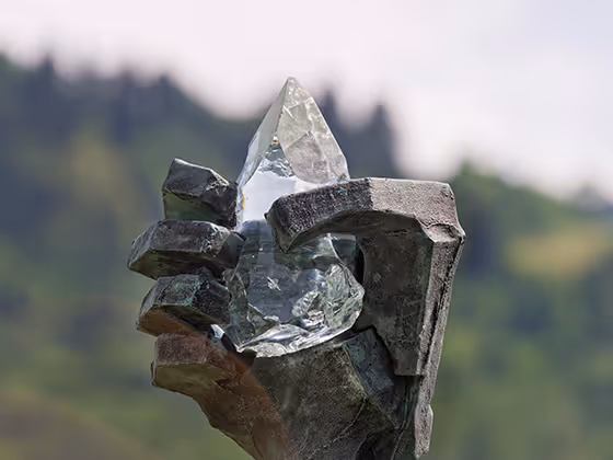 Skulptur 'Airs and Graces': Monumentale Bronzeskulptur einer Hand, die einen Kristall hält, im Park aufgestellt.