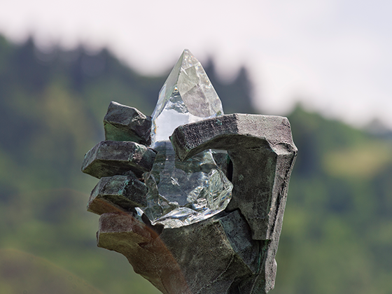 Skulptur 'Airs and Graces': Monumentale Bronzeskulptur einer Hand, die einen Kristall hält, im Park aufgestellt.