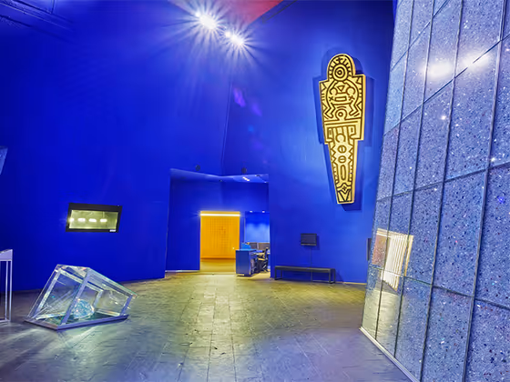 Die Blaue Halle: Ein Raum mit intensiver in einem Blau, mit vielen Kunstwerken an den Wänden. In der Mitte ein großer Kristall.