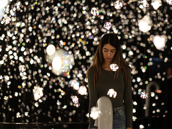 Installation 'Pulse Voronoi': Eine Junge Frau steht inmitten eines Raumes voller Kristalle.