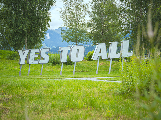 Installation 'Yes to All': Überdimensionaler Kristallschriftzug, der eine Botschaft von Offenheit vermittelt.
