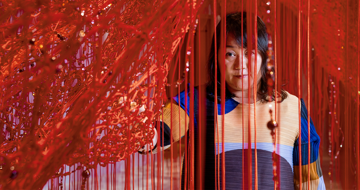 Die japanische Künstlerin Shiota in ihrer Wunderkammer mit unzähligen roten Fäden.