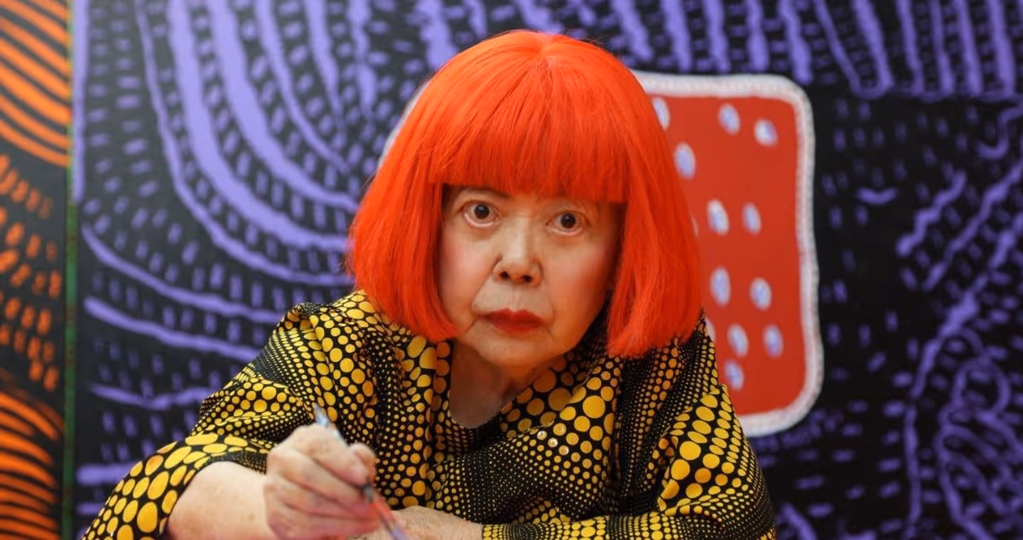 Yayoi Kusama, japanische Künstlerin, im Porträt mit rotem Haarschnitt, bekannt für ihre Polka-Dot-Muster.