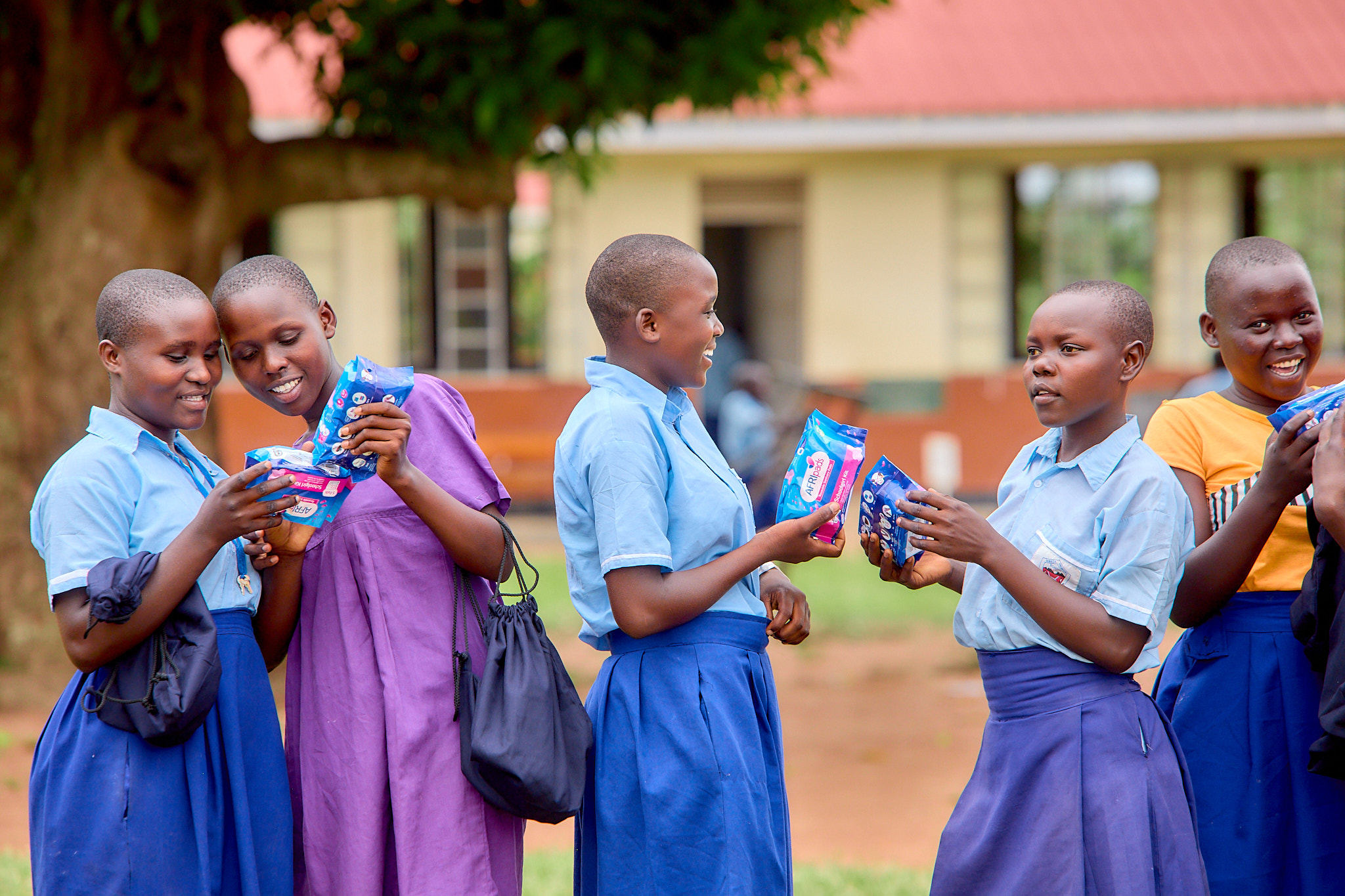 Girls holding afripads packs