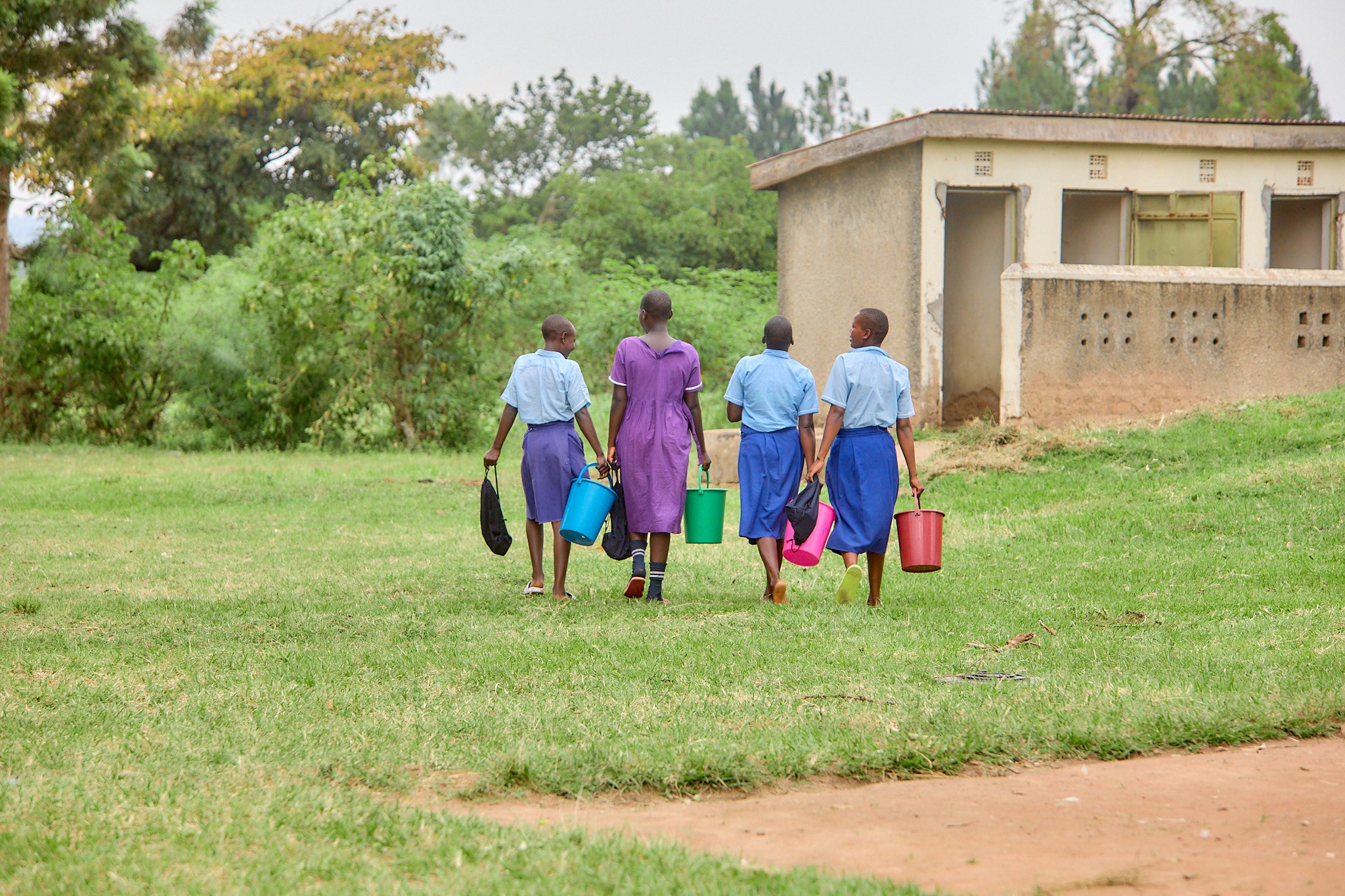 Girls walking away with buckets