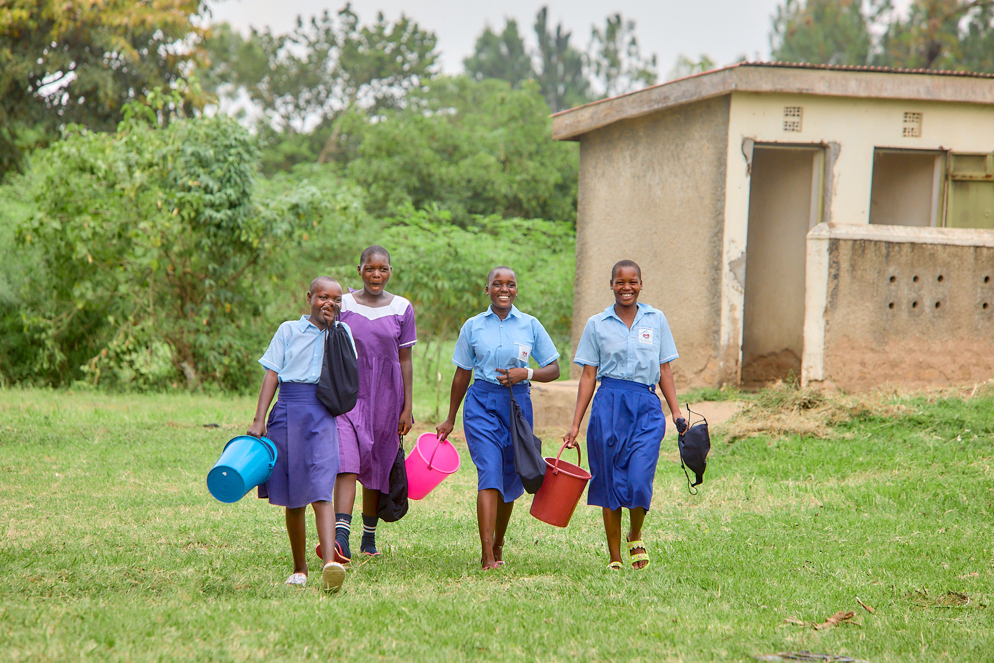 Girls smiling and walking with buckets