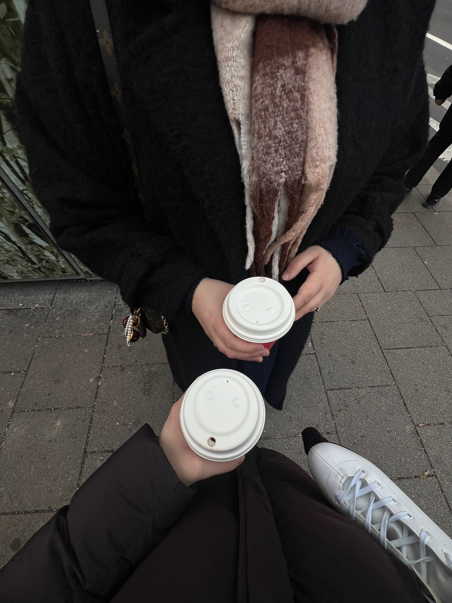 Illustration von zwei Frauen, die entspannt einen Kaffee to go trinken. Symbolbild für niederschwellige Treffen, um eine Freundschaft ohne Druck aufzubauen und Zeit miteinander zu verbringen