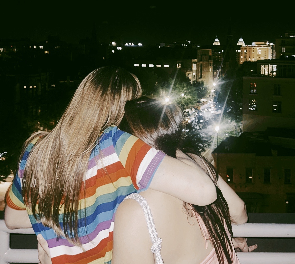 Rückenansicht zweier Frauen, die sich nachts im Arm halten – Symbolbild für emotionalen Halt, Trost und tiefe Verbundenheit in einer Freundschaft.