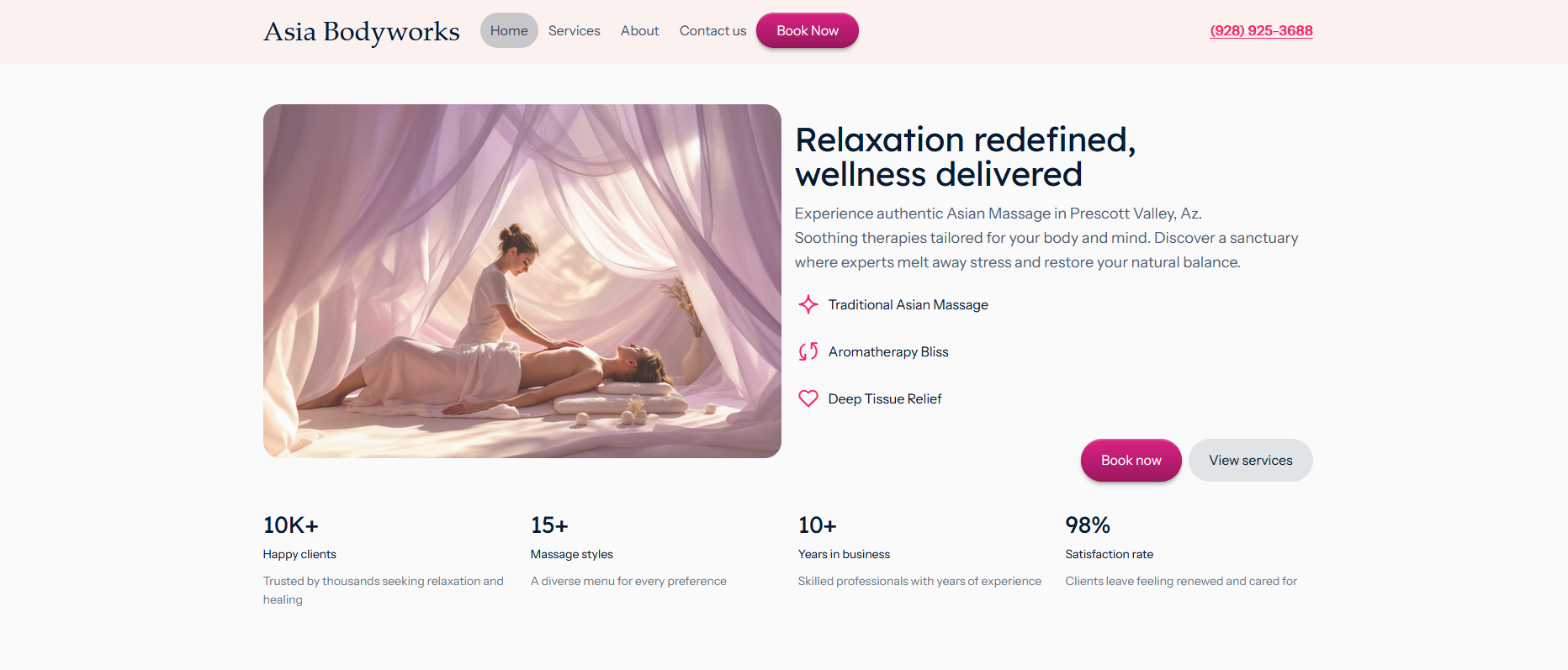 Woman receiving a massage while lying on a cushion under sheer pink curtains in a softly lit room.