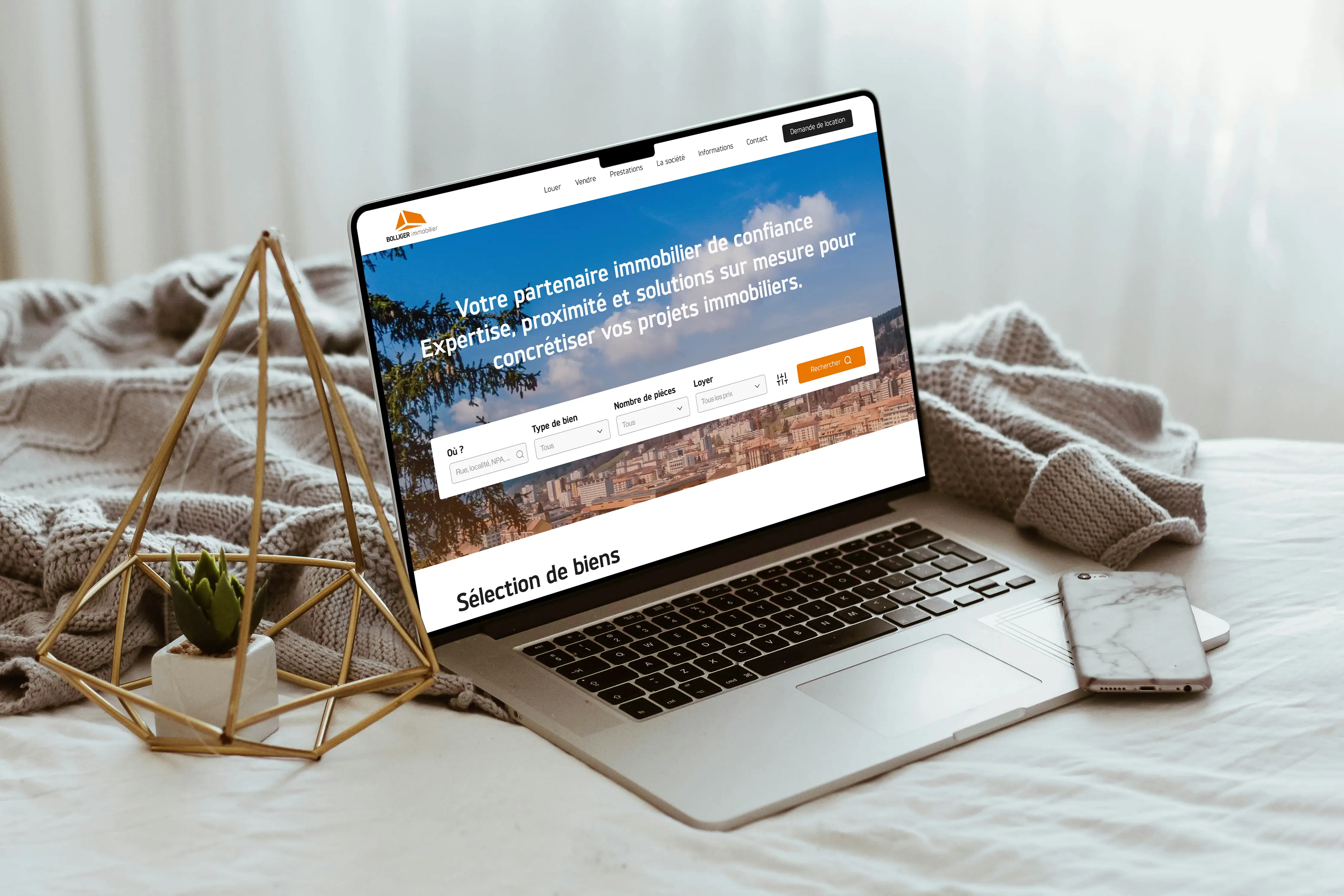 Site Bolliger afficher sur un macbook, le macbook est posé sur un lit