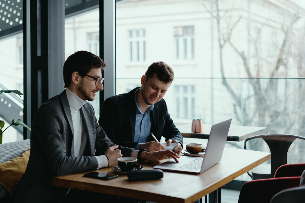 men using laptop and talking - How to Create an AI Agent 