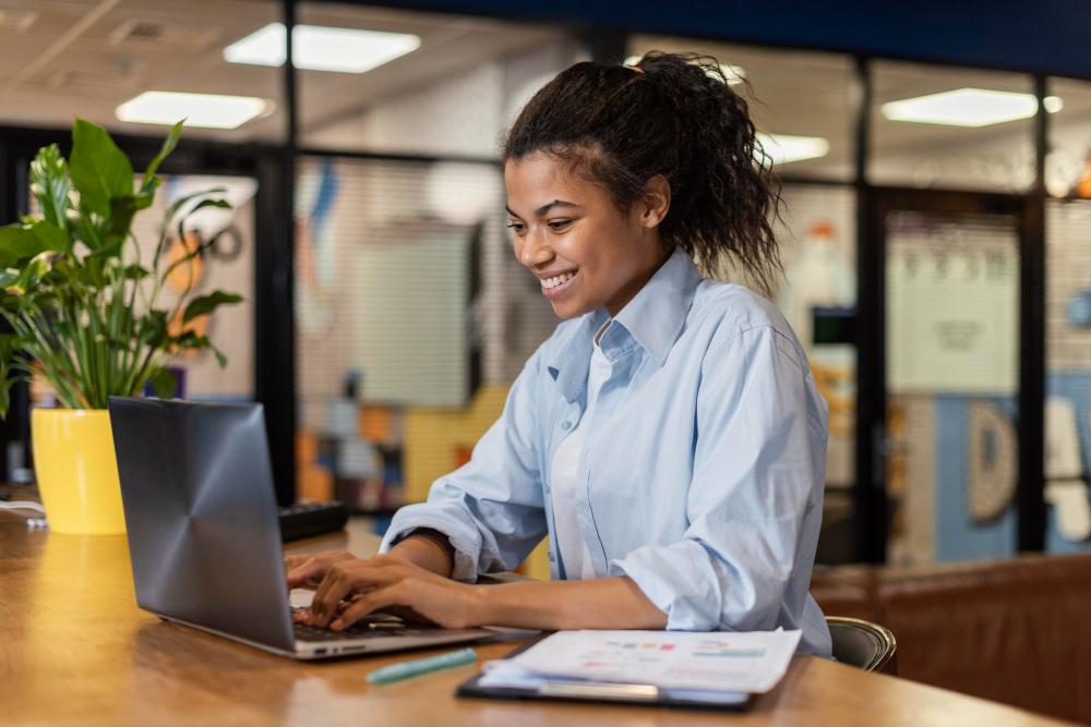 woman smiling and using a laptop - AI Workflows 