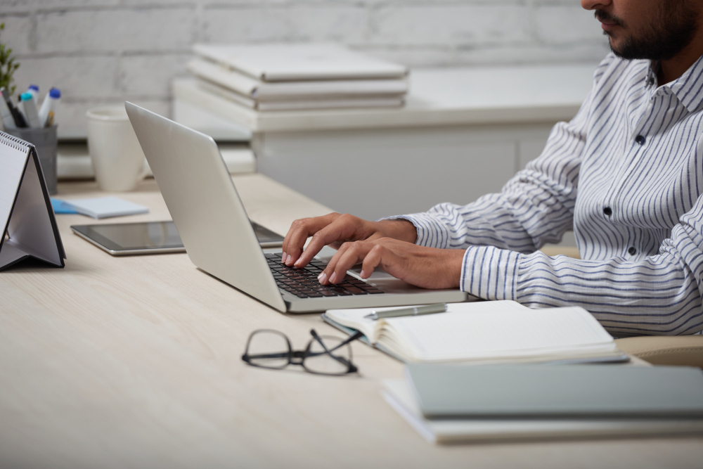 man typing on a sikver laptop - AI Workflows 