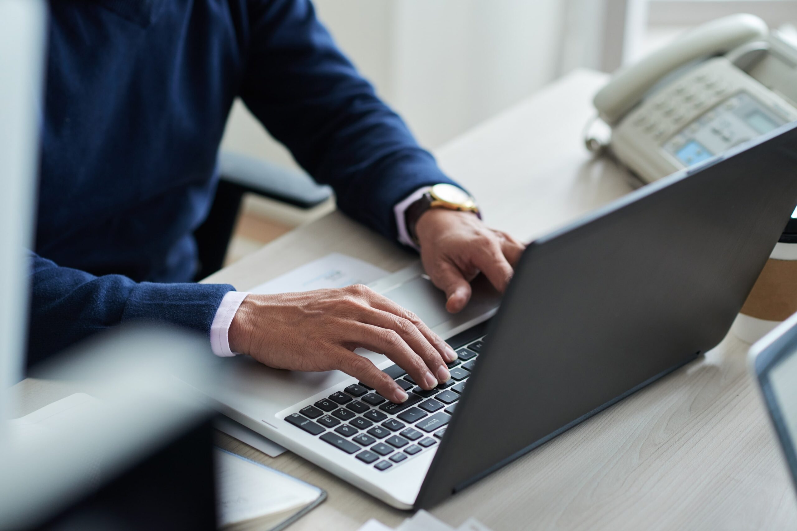 man typing on a laptop - Best AI Market Research Tools