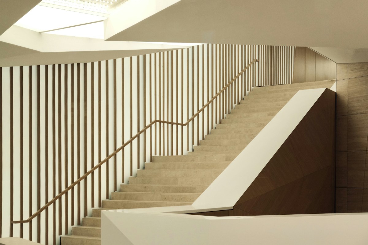Sculptural staircase with warm timber details and soft natural light