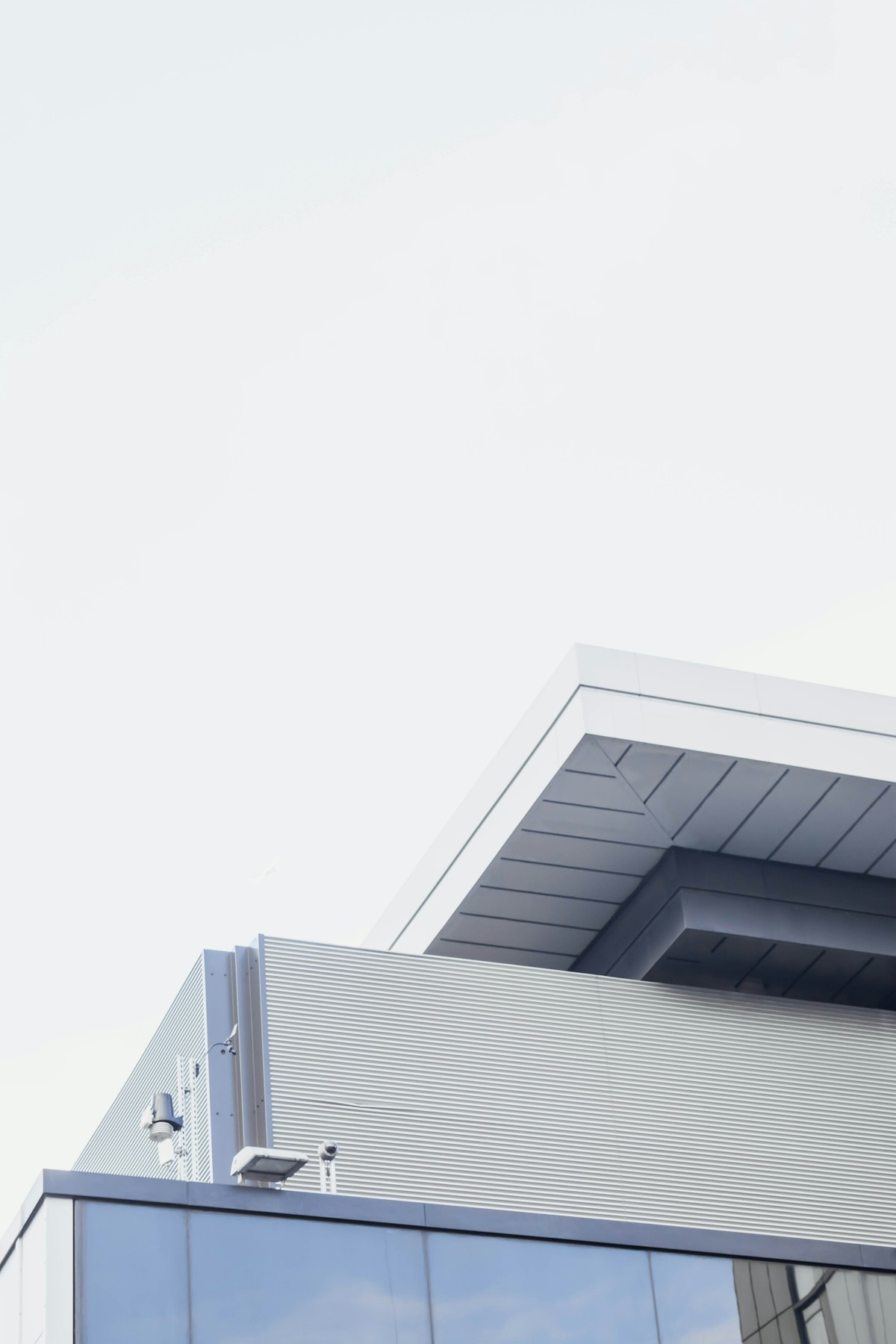 Minimal white building facade against a pale sky